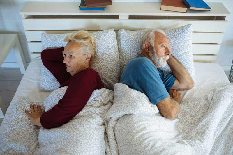 沮丧的老夫妇躺在床上